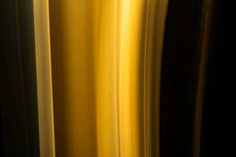 A close up macro photo of a vertical wisp of orange smoke on a black backgrou Stock Photos