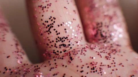 Close-up macro of a pink glitter on the hands of a kid. .macro photo of pink  Stock Photos