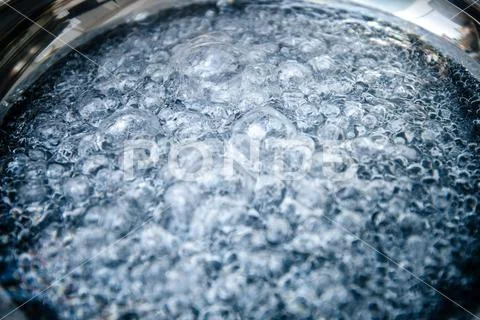 Close-up macro shot of boiling water inside new frying stainless steel Stock Photos