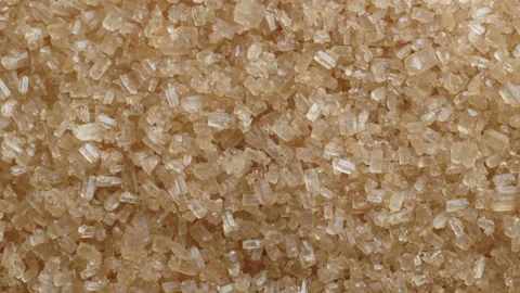 Close up macro shot of brown demerara sugar slowly rotating 01. 4K locked tripod Stock Footage 153769006