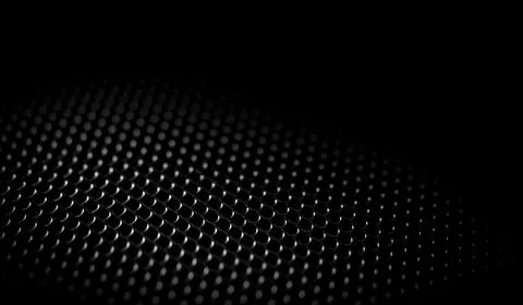 Close-up macro shot of a dark metallic grid with a honeycomb pattern and so.. Illustrazione stock