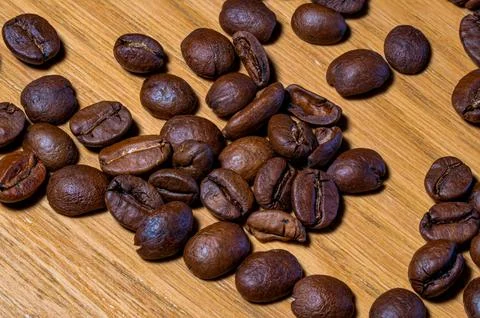 Close-up Macro Shot of Dark Roasted Coffee Beans Scattered Across a Texture.. Stock Photos