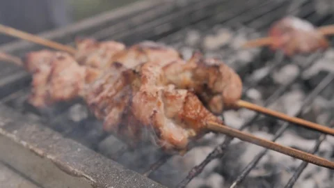 Close-up (macro shot) of delicious meat slices on wooden skewers fried outdoors Stock Footage 126041825