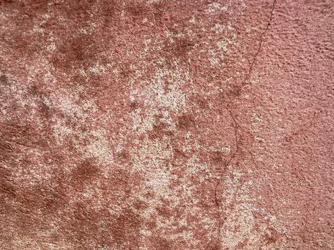 Close macro shot of a distressed red concrete surface featuring peeling pai.. Foto stock
