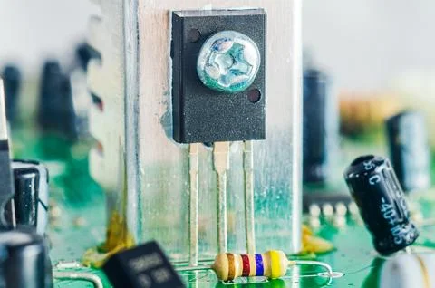 Close-up macro shot of electronic components on a green circuit board with .. Stock Photos