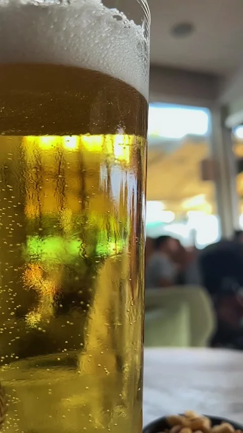Close-up macro shot of a glass filled with cold beer, bubbles rise slowly Stock Footage 287015253