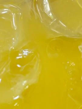 Close Up Macro Shot of Ice Cubes in Fresh Orange Juice Drink Stock Photos