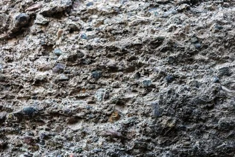 Close-up macro shot of a rough stone or concrete surface with natural erosion Stock Photos