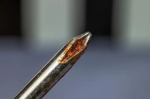 Close-up macro shot of a rusty Phillips head screwdriver tip showing corros.. Stock Photos