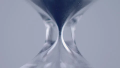 Close up macro shot of sand clock / hourglass sand pouring in slow motion. Video stock 273114495