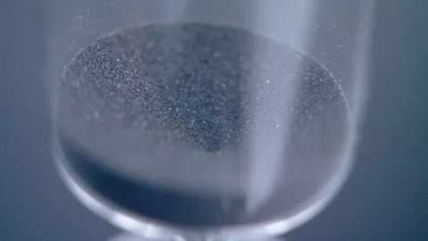 Close up macro shot of sand clock / hourglass sand pouring in slow motion. Stock Footage 273114750