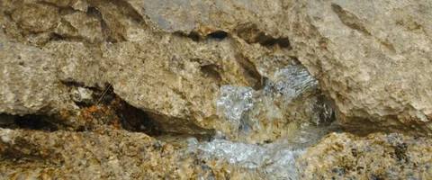Close-up macro shot of small wave flow through rocks in slowmotion Stock Footage 97897585