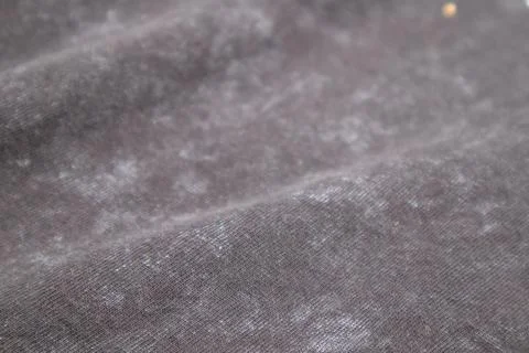 Close-up macro shot of washed grey fabric texture with soft folds and acid-.. Stock Photos