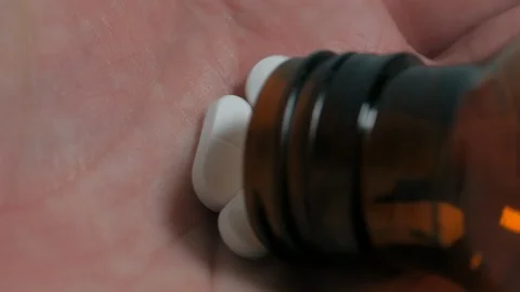 Close up / macro shot of white pills in palm of hand. Stock Footage 111478159