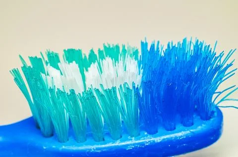 Close-up macro shot of a worn blue and teal toothbrush bristles against a n.. 스톡 사진