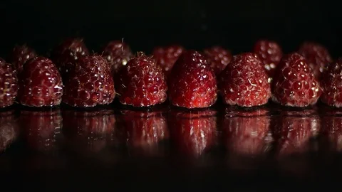 Close up macro studio shot of many fresh red raspberries on a black background Vídeo Stock 114514501