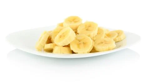 Close-up macro studio shot of sliced banana on plate on white background Stock Photos