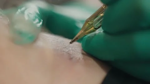 Close-up macro of tattooing process, master in gloves works with machine. Stock Footage 219549181