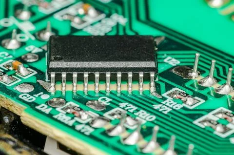 Close-up macro view of a black integrated circuit chip on a green printed c.. Photos