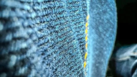 Close-up macro view of blue jeans. Pants from denim with yellow stitches Stock Photos
