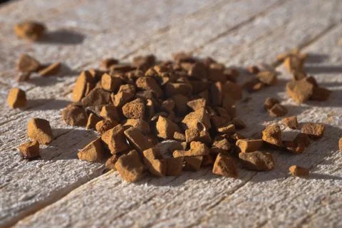 Close-up macro view of brown granules scattered across Stock Photos
