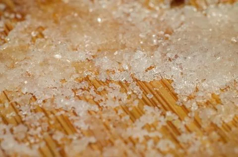 Close-up macro view of coarse salt crystals scattered on a wooden surface Fotos de archivo