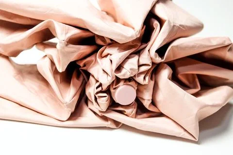 Close-up macro view of the crumpled, folded pink fabric layers of a compact.. Stock Photos