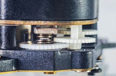 Close-up macro view of intricate clockwork gears and a small spring mechanism Stock Photos