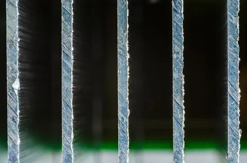 Close-up macro view of rough, textured metal bars with light shining throug.. Stock Photos