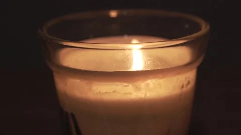 Close macro view of white cream wax home candle in glass pot. fire turned Video stock 154567441