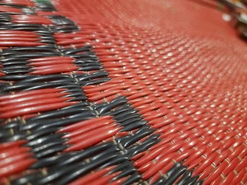 Close up macro view of woven plastic mat texture with red and black pattern Stock Photos