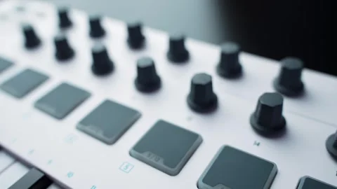 Close-up macro of a white MIDI controller showing drum pads and rotary knobs 库存影片 331108052