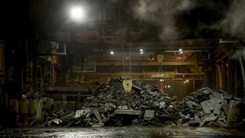 Close up of magnetic crane inside steel mill from exterior at night Stock Footage 89945495