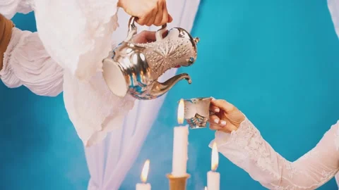 Close-up maid hand pouring tea from teapot into cup of woman queen. Body part Stock Footage 310307858