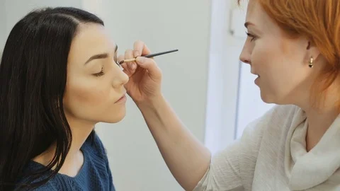 Close-up of a make-up artist applying make-up to the eyelash Stock Footage 73646365