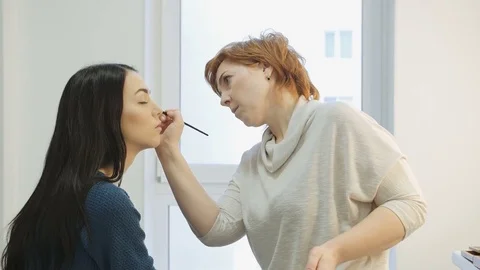 Close-up of a make-up artist applying make-up to the eyelash Stock Footage 73646578
