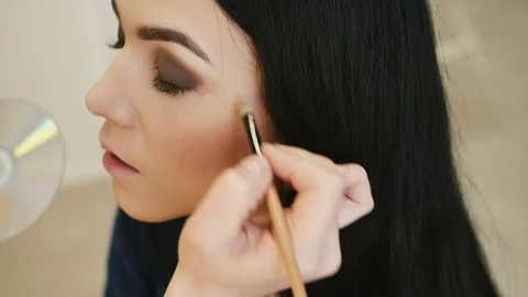 Close-up of a make-up artist applying make-up to the eyelash Video stock 73780951