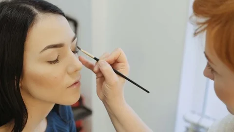 Close-up of a make-up artist applying make-up to the eyelash Stock Footage 73847658