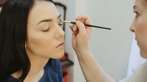Close-up of a make-up artist applying make-up to the eyelash Stock Footage 73848389
