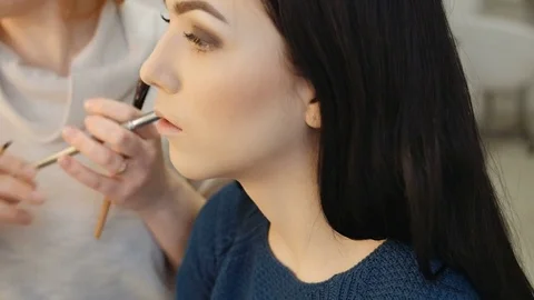 Close-up of a make-up artist applying make-up to the eyelash Stock Footage 73850365