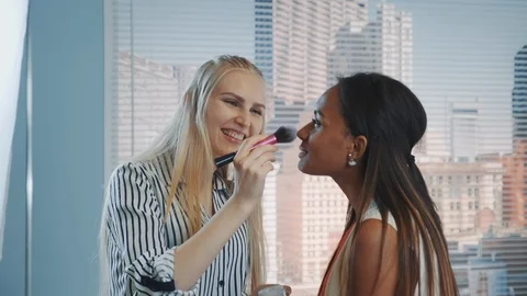 Close-up of make-up artist applying makeup on black model with skyscrapers in Stock Footage 122574675