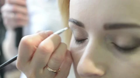 Close-up Make up Artist does the Shadow on the Eyelid for Girl Model Stock Footage 61525788