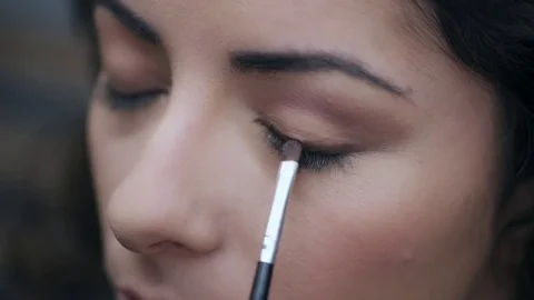 Close up on Make up artist's hand applying with a brush eyeshadow on the eye Stock Footage 74720618