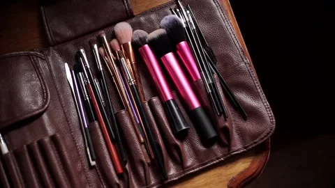 Close-up of make-up tassels that lie in a leather bag. Top view Video stock 200409193