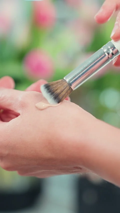 Close-up of makeup artist applying and testing liquid foundation tone on ha.. Stock Footage 332660740