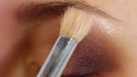 Close up of makeup artist is applying eyeshadow powder on the woman's eyelid Stock-Footage 82709668