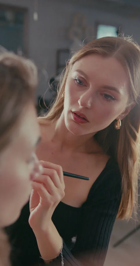 Close-up of a makeup artist applying makeup to a models face. 스톡 동영상 322863287