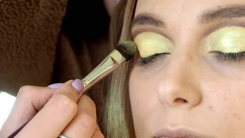 Close-up of a makeup artist using a brush to apply eyeshadow  Stock Footage 199425628