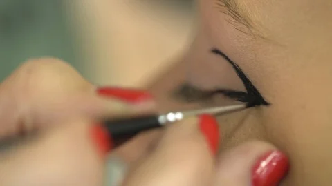 Close-up Of A Makeup Artist's Hands With Red Fingernails Painting Model's Eyes Stock Footage 128388501