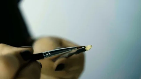 Close up of a makeup brush moving over mixing pallete 스톡 동영상 82061377